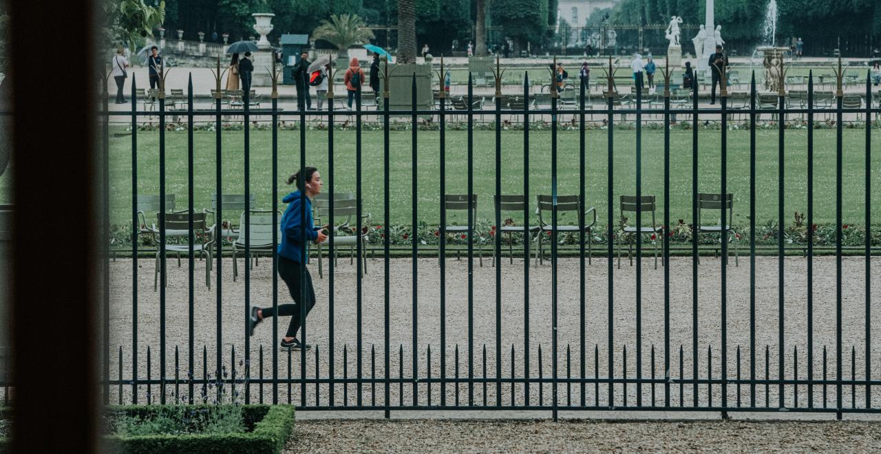 A woman running behind a fence