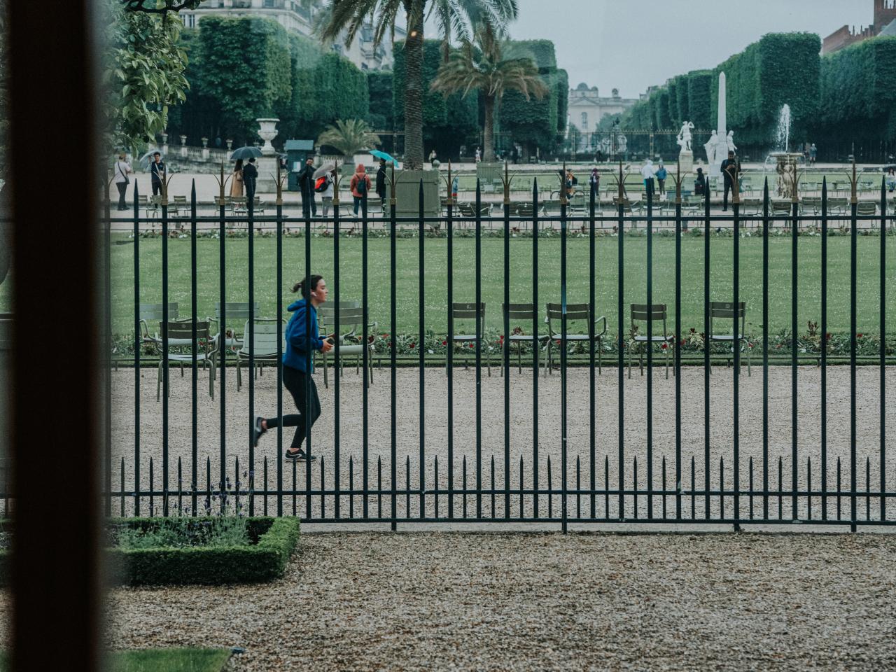A woman running behind a fence