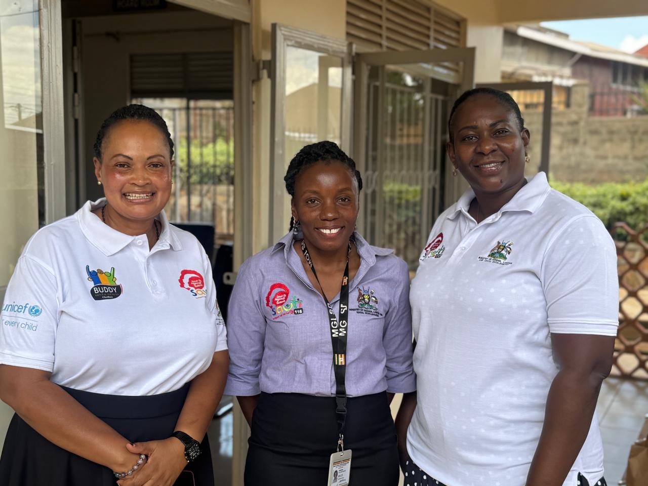 Three female sauti counsellors stand in front of their building