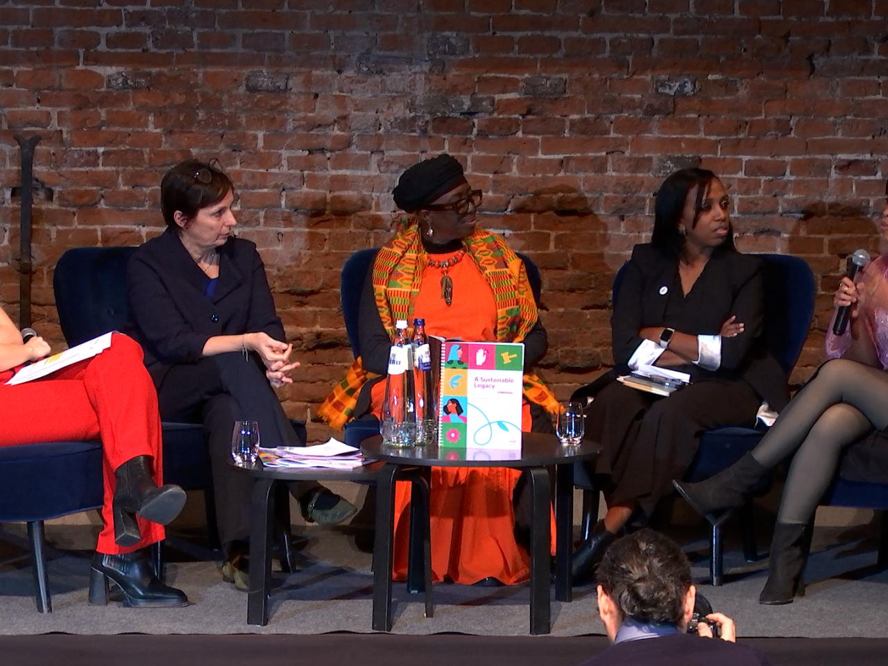 five women seated on stage