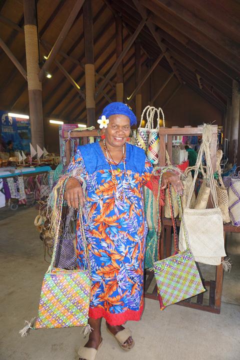 A market vendor shows off her handicrafts in the market, Port Vila, Vanuatu.  