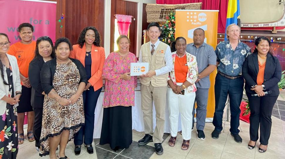 A group photo of 11 participants, Hon. Vice President and Minister of Justice, Ms Uduch Sengebau Senior and UNFPA Pacific Director Iori Kato in the centre holding the document together