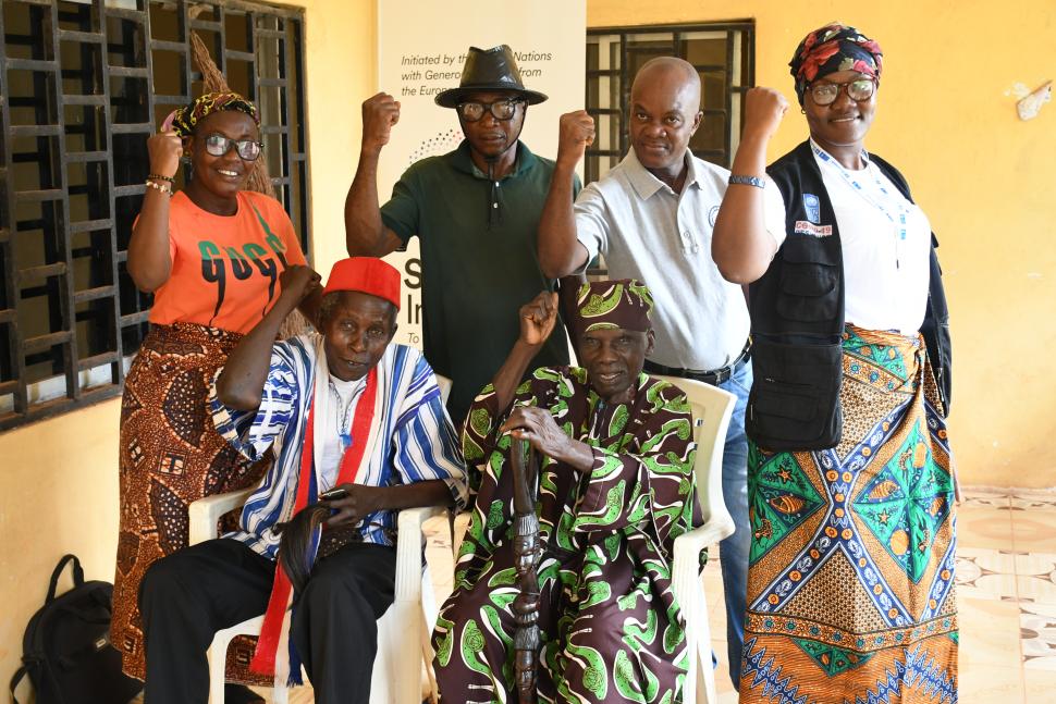 Five men and women smiling and raising fists in the air