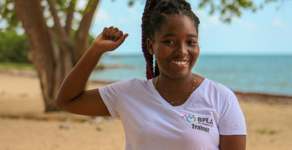 A smiling young woman raises a fist