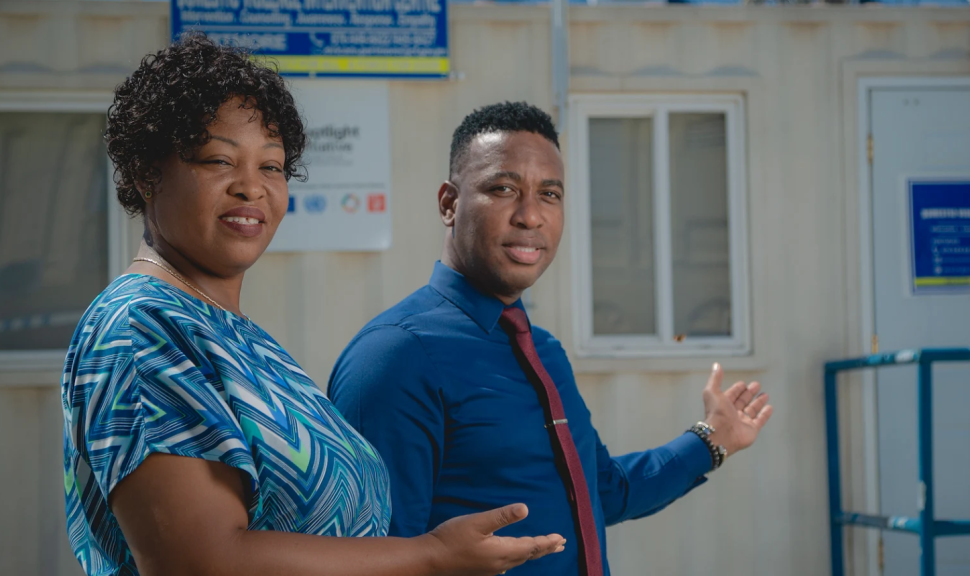 Man and woman sweep hands towards a mobile centre