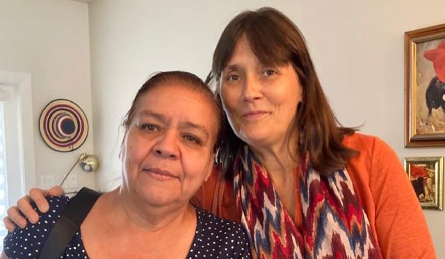 Two women, one with arm around other's shoulder