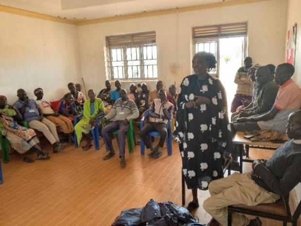 A woman stands in front of seated people in a classroom