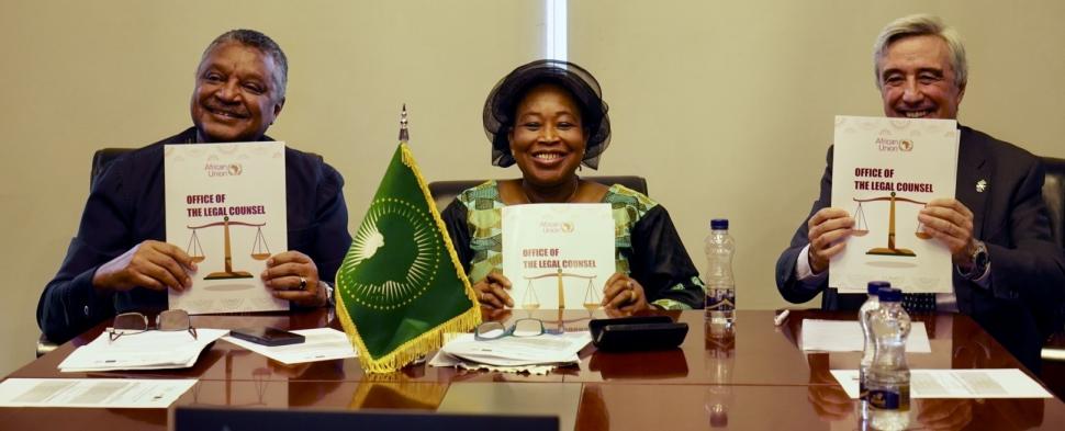 Three people smiling and holding up document