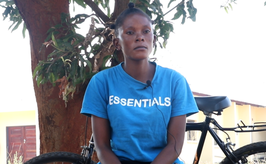 Woman sitting under tree in front of bicycle