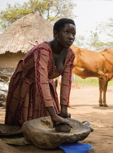 A woman in a red dress using a mortar and pestle