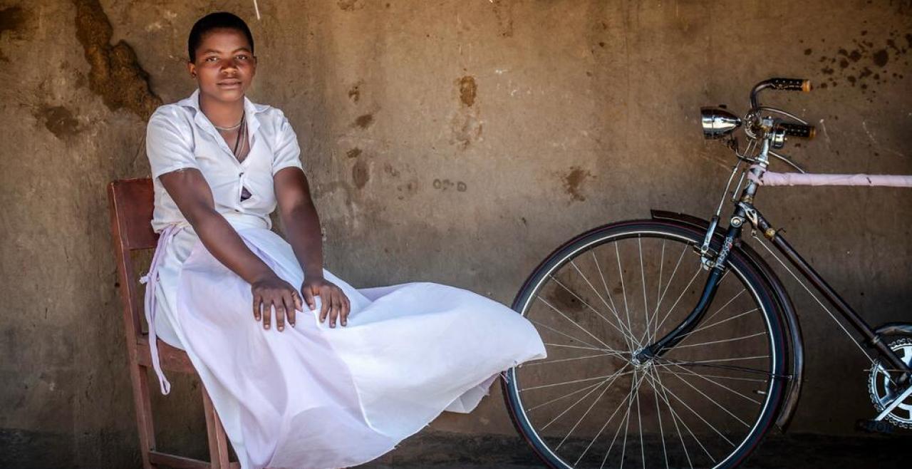 Girl in white dress beside a bicycle