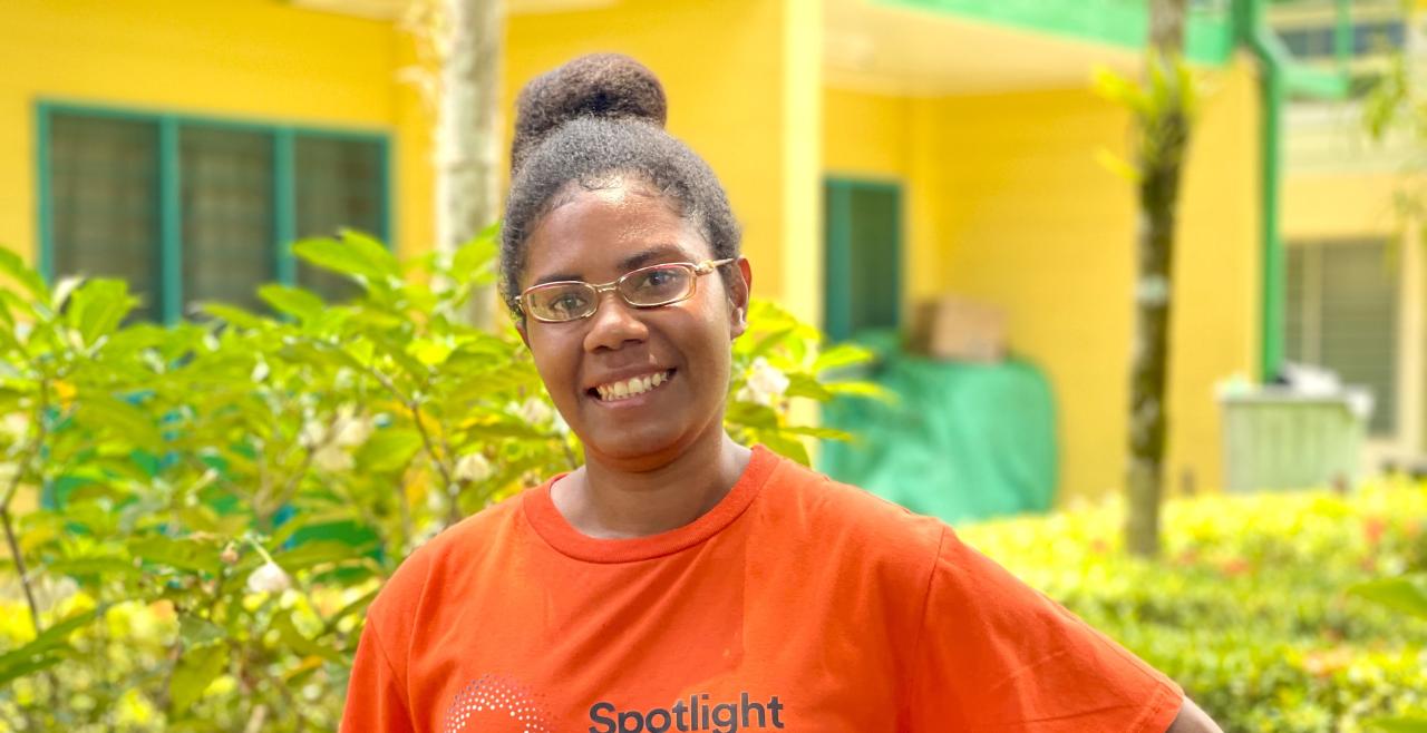 Smiling woman in an orange Spotlight branded t-shirt
