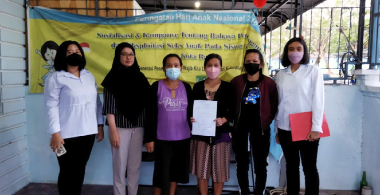 six masked women stand in front of sign