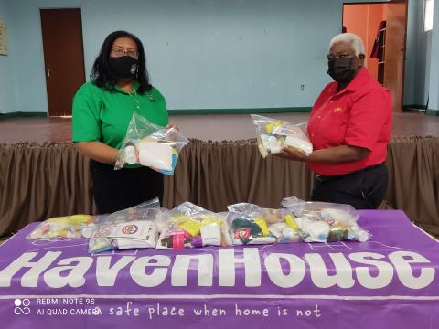 Two women in masks holding PPE