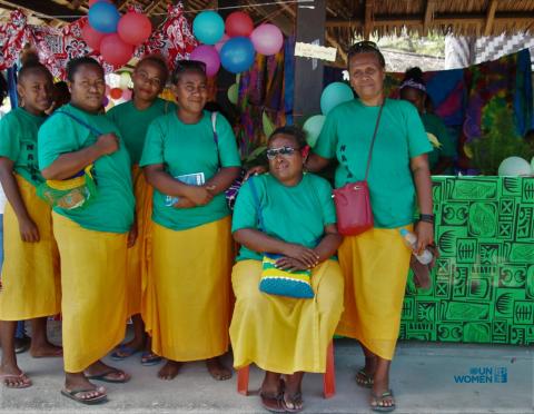 6 women in green shirts and yellow skirts